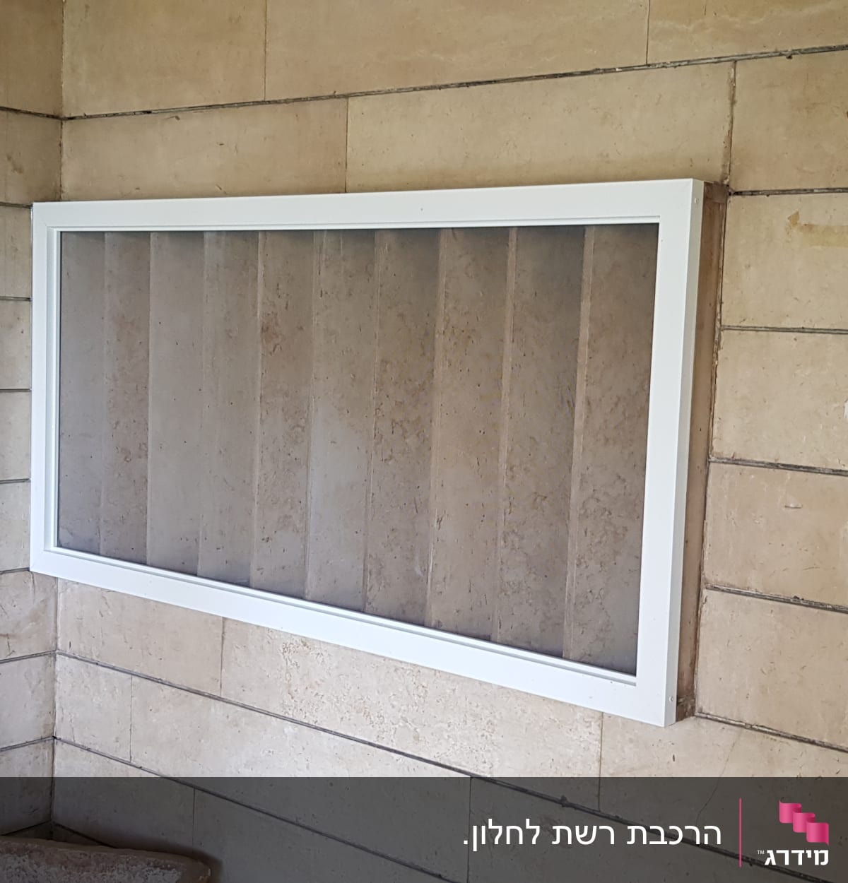 מסגרת אלומיניום לבנה על קיר אבן